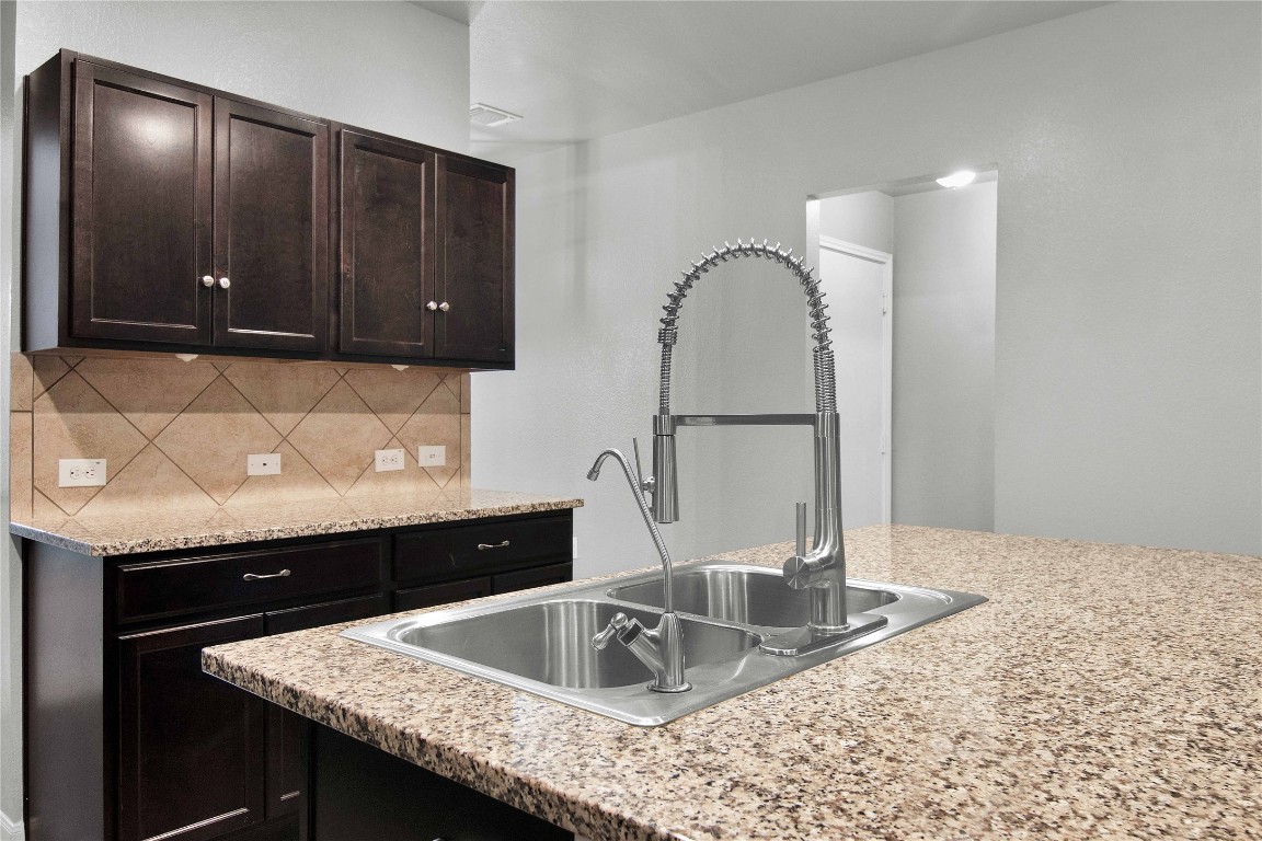 704 Red Tails Drive Austin, TX 78725 - Photo 8 of 37 a kitchen with a sink and a cabinets