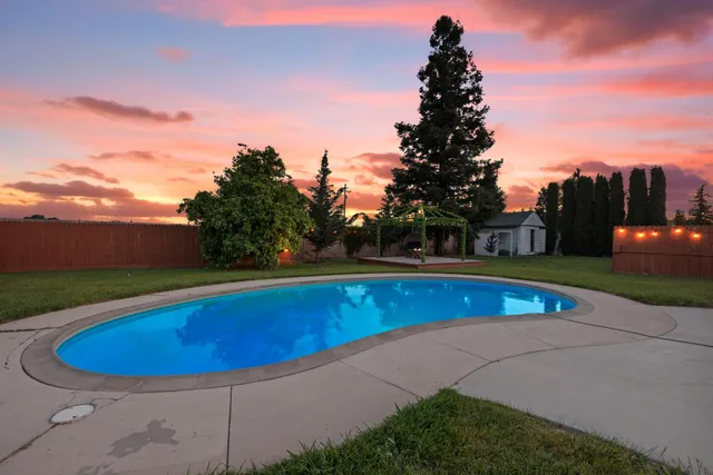a view of a swimming pool with an outdoor seating and a garden