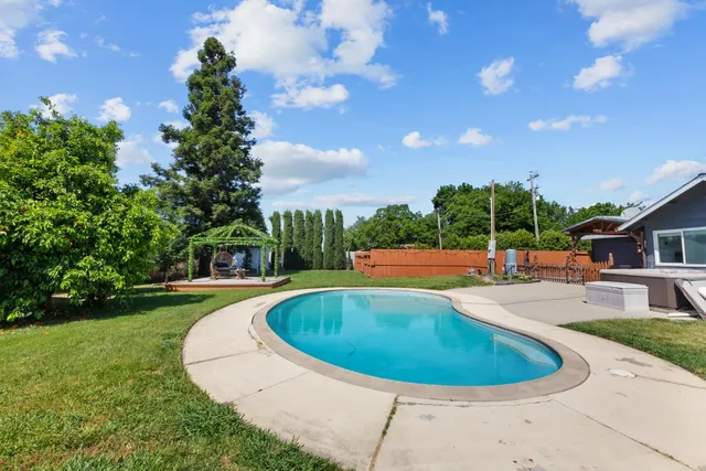 a swimming pool with outdoor seating and yard