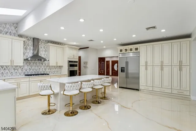 a kitchen with stainless steel appliances kitchen island granite countertop a refrigerator and cabinets