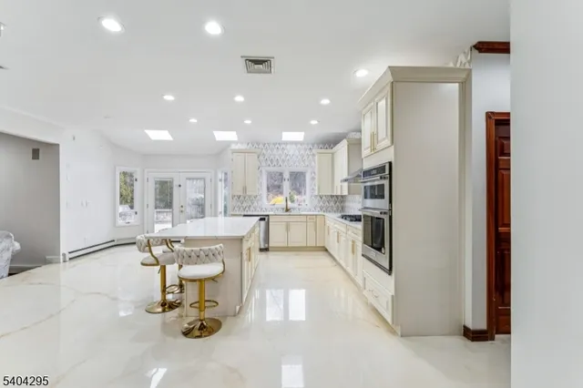 a large kitchen with stainless steel appliances granite countertop a stove and a sink