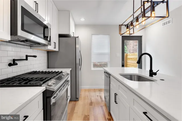 a kitchen with stainless steel appliances a sink stove and refrigerator