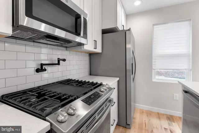 a stove top oven sitting inside of a kitchen