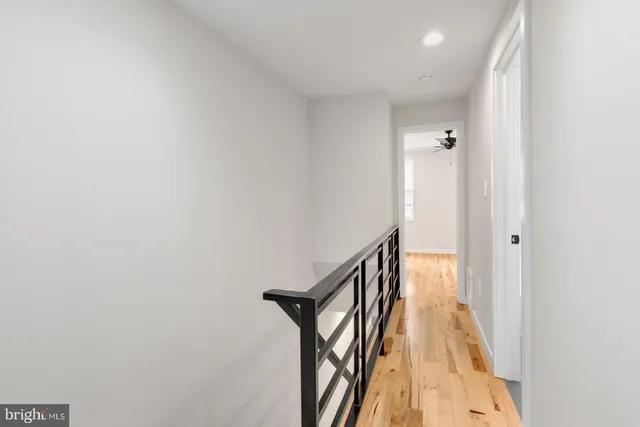 a view of a hallway with wooden floor and staircase