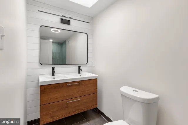 a bathroom with a toilet sink and mirror