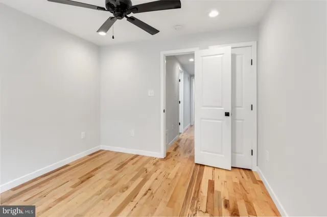 a view of a big room with wooden floor and a ceiling fan