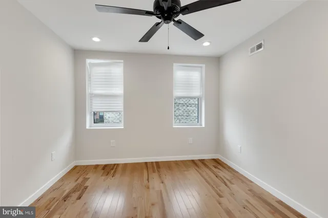 an empty room with a window and wooden floor