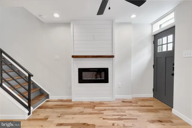 a view of a livingroom with wooden floor and a fireplace