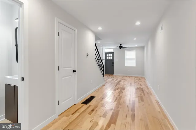 a view of a hallway with wooden floor and staircase