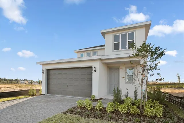 a front view of a house with a garden and yard