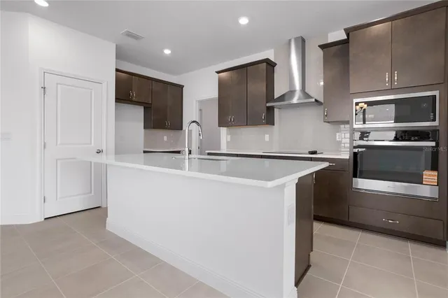 a kitchen with kitchen island a sink stainless steel appliances and cabinets
