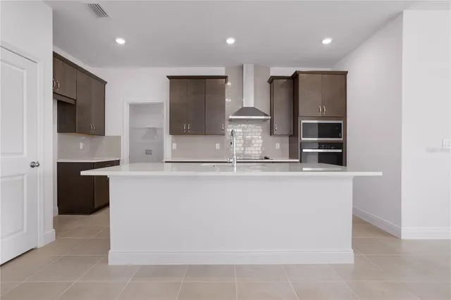 a kitchen with kitchen island stainless steel appliances a sink and a refrigerator