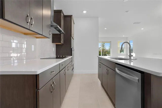 a kitchen with granite countertop a sink and stainless steel appliances