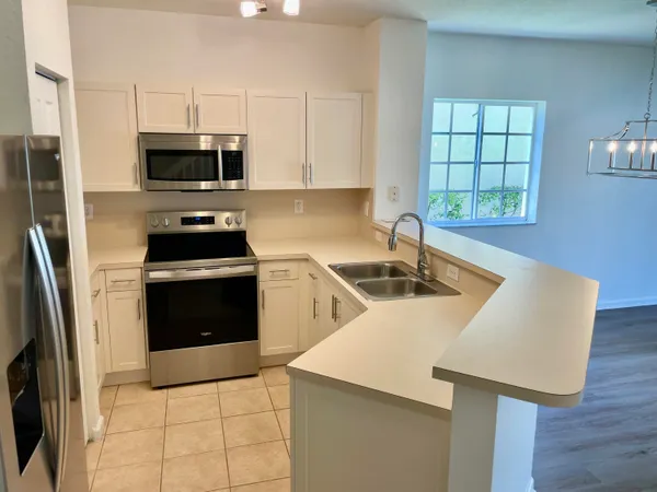 a kitchen with stainless steel appliances a stove a sink a microwave and cabinets