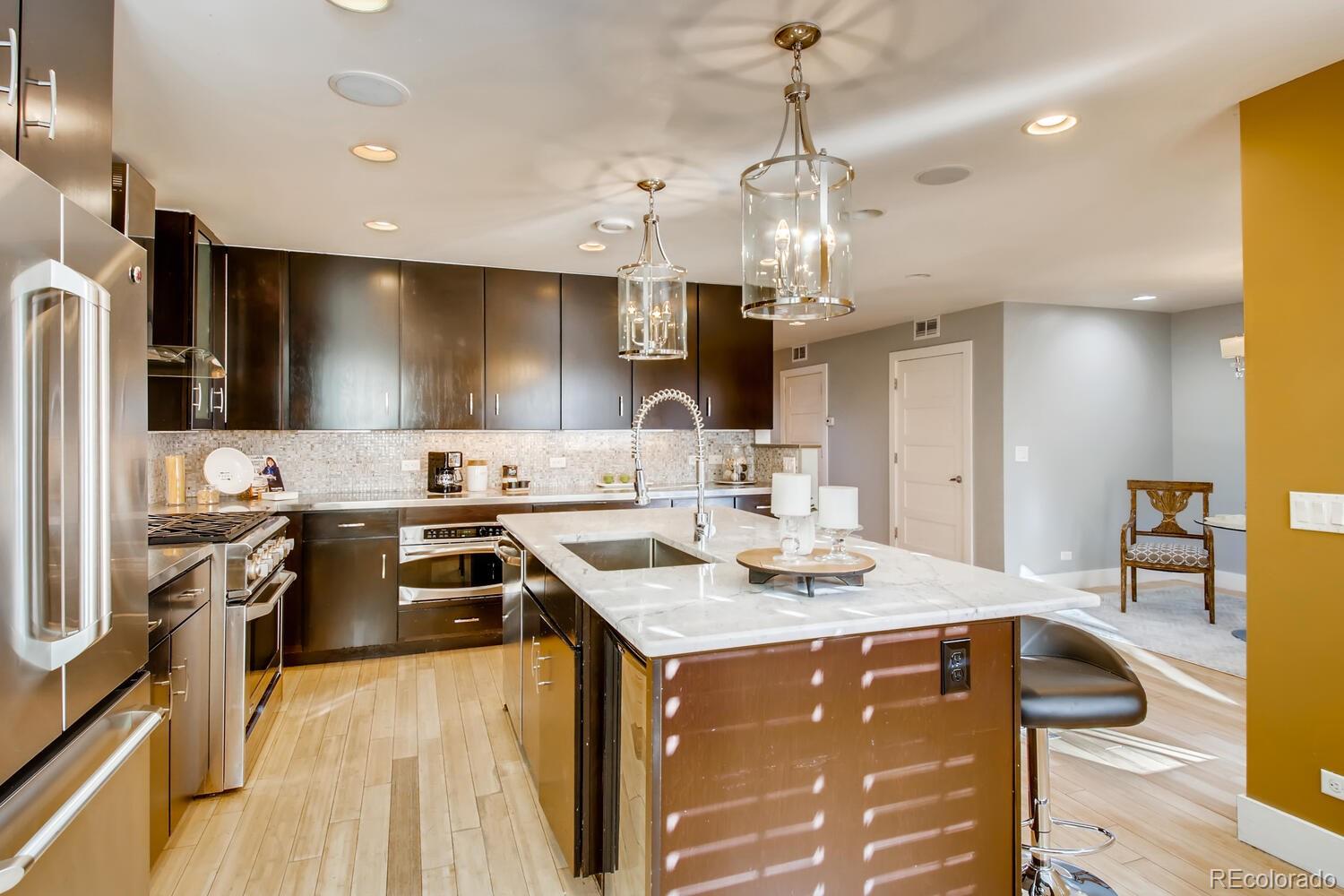 1635 Gilpin Street Denver, CO 80218 - Photo 12 of 39 a kitchen that has a lot of cabinets in it and stainless steel appliances