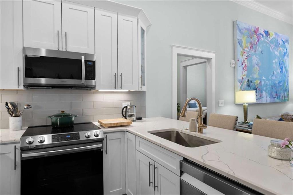 1 East 3rd Avenue, Unit 310 Rome, GA 30161 - Photo 11 of 25 a kitchen with cabinets a sink and a stove top oven