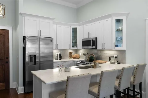 a kitchen with stainless steel appliances granite countertop a sink a microwave refrigerator and a refrigerator