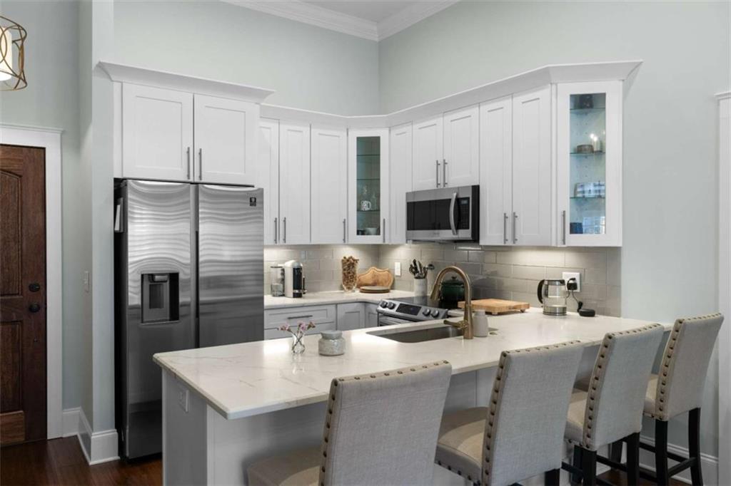 1 East 3rd Avenue, Unit 310 Rome, GA 30161 - Photo 8 of 25 a kitchen with stainless steel appliances granite countertop a sink a microwave refrigerator and a refrigerator