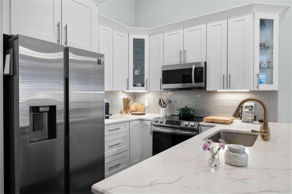 1 East 3rd Avenue, Unit 310 Rome, GA 30161 - Photo 10 of 25 a kitchen with stainless steel appliances granite countertop a refrigerator a stove a sink and white cabinets