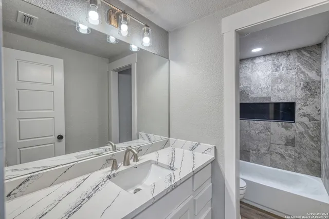 a bathroom with a shower and a sink