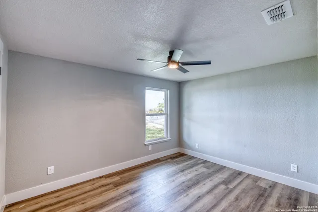 wooden floor in an empty room with a window