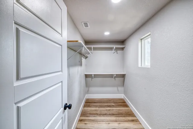 a view of an empty room and window and ceiling fan