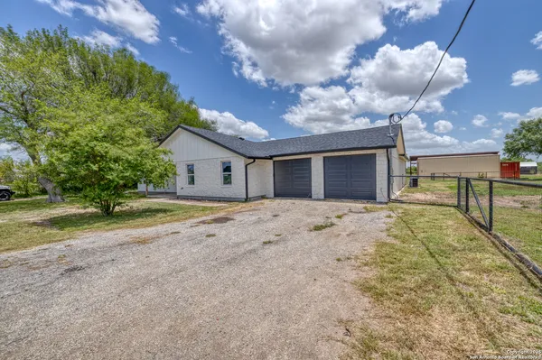 a view of a house with backyard and a tree
