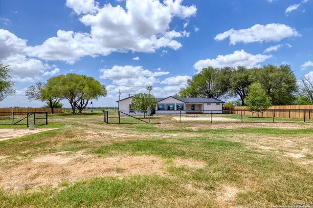 an aerial view of residential houses with outdoor space and trees