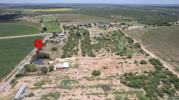 a view of a green field with wooden fence