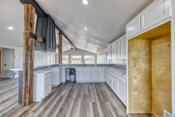 a kitchen with cabinets and wooden floor