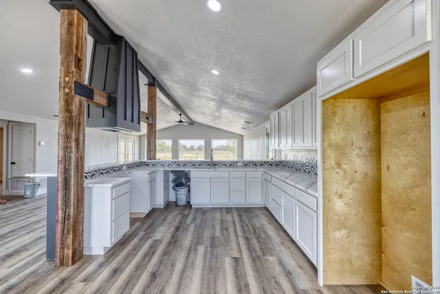 a kitchen with cabinets and wooden floor