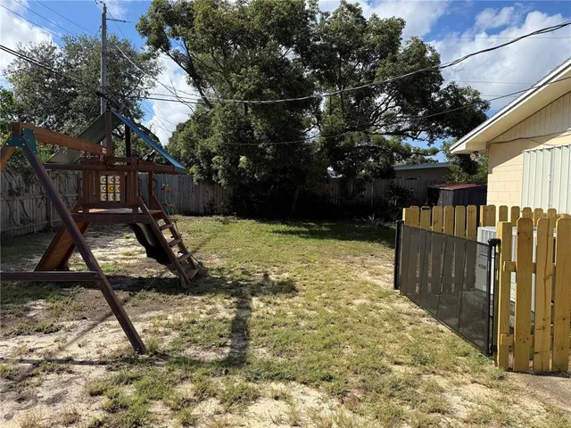 a view of a backyard with wooden fence