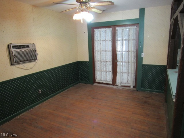 3102 State Road Vermilion, OH 44089 - Photo 21 of 45 Spare room featuring dark hardwood / wood-style flooring, an AC wall unit, french doors, and ceiling fan