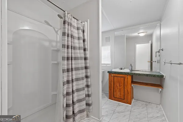 a bathroom with a sink a mirror and a shower