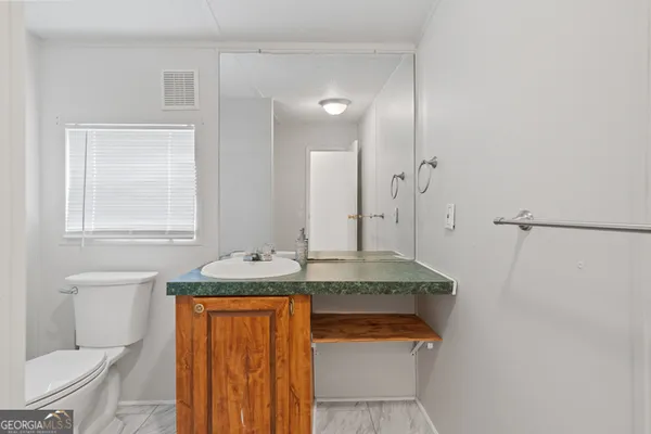 a bathroom with a granite countertop sink and a mirror
