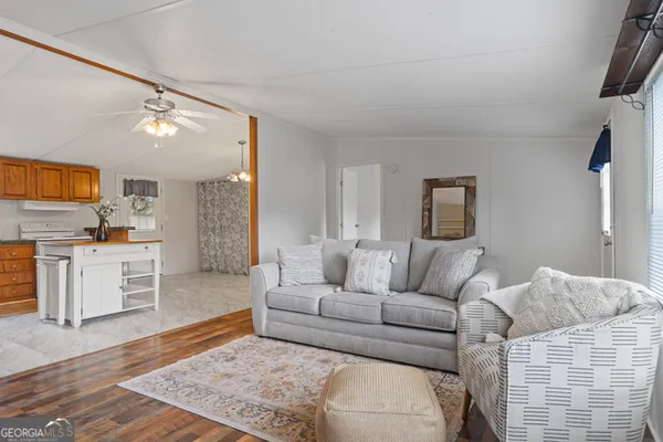 a living room with furniture and a kitchen