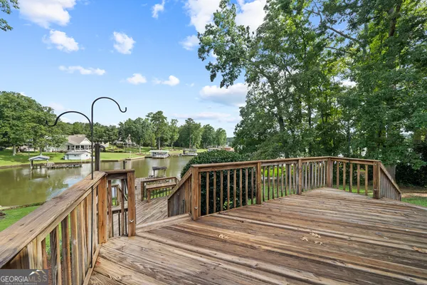 a balcony with wooden floor and lake view