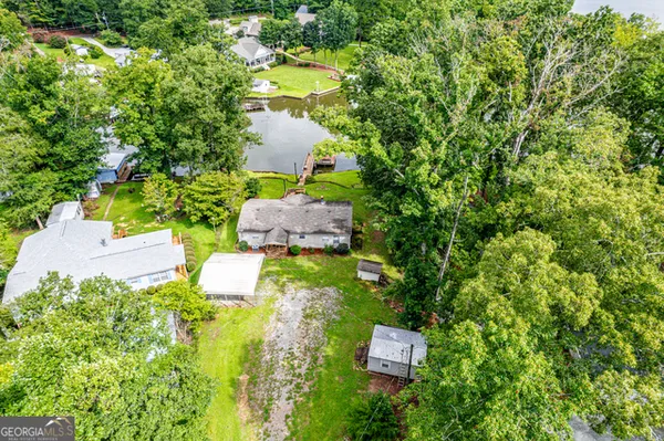 an aerial view of residential houses with outdoor space and lake view