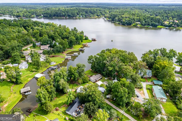 an aerial view of a house with a yard and lake view
