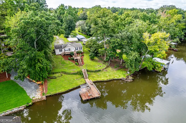 an aerial view of a house with swimming pool a yard and lake view