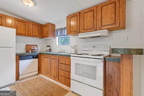 a kitchen with stainless steel appliances granite countertop a refrigerator sink and cabinets