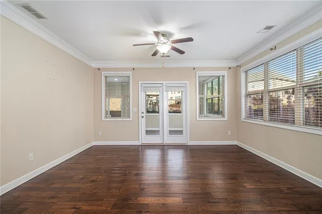 a view of a big room with wooden floor and windows