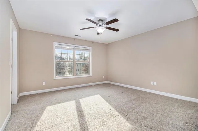 a view of an empty room with a ceiling fan