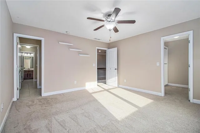 an empty room with windows and ceiling fan