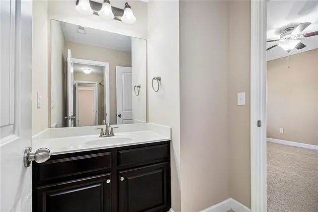 a view of empty room with wooden floor and kitchen view