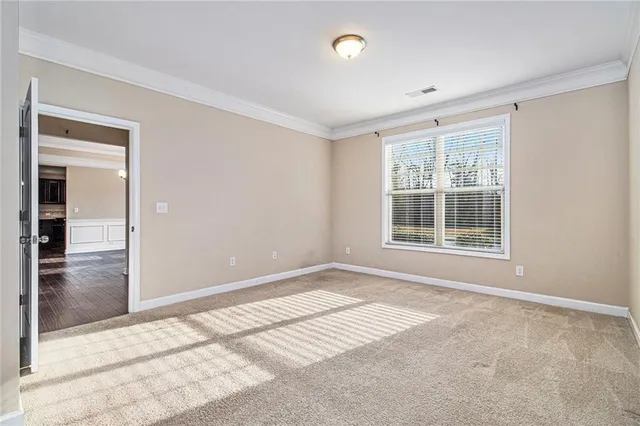 a view of an empty room and chandelier fan