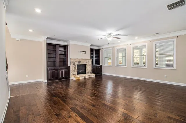 a view of an empty room with window and wooden floor