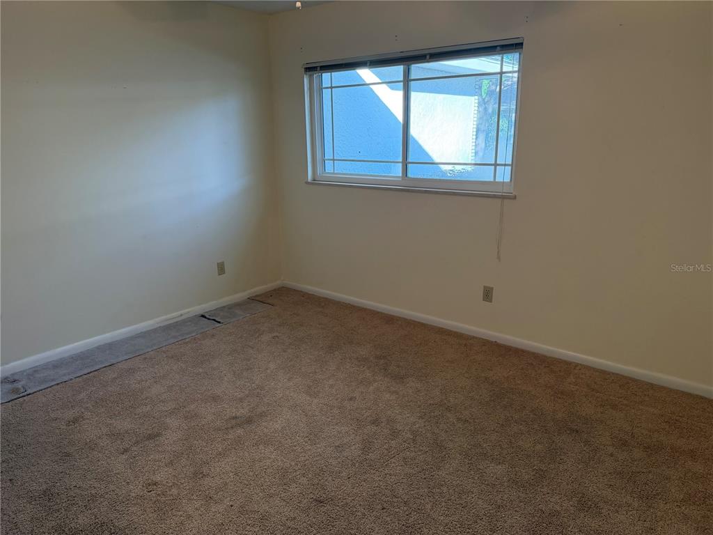 9529 Southwest 85th Avenue, Unit D Ocala, FL 34481 - Photo 16 of 21 an empty room with a window