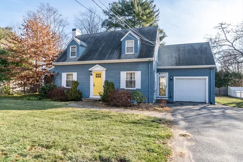 a front view of a house with a garden and yard