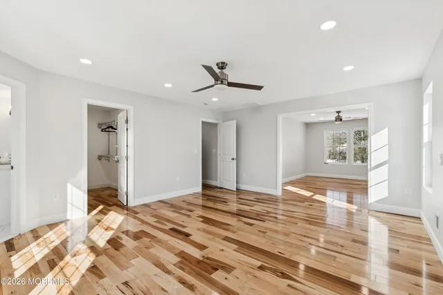 a view of a livingroom with a chandelier fan and wooden floor